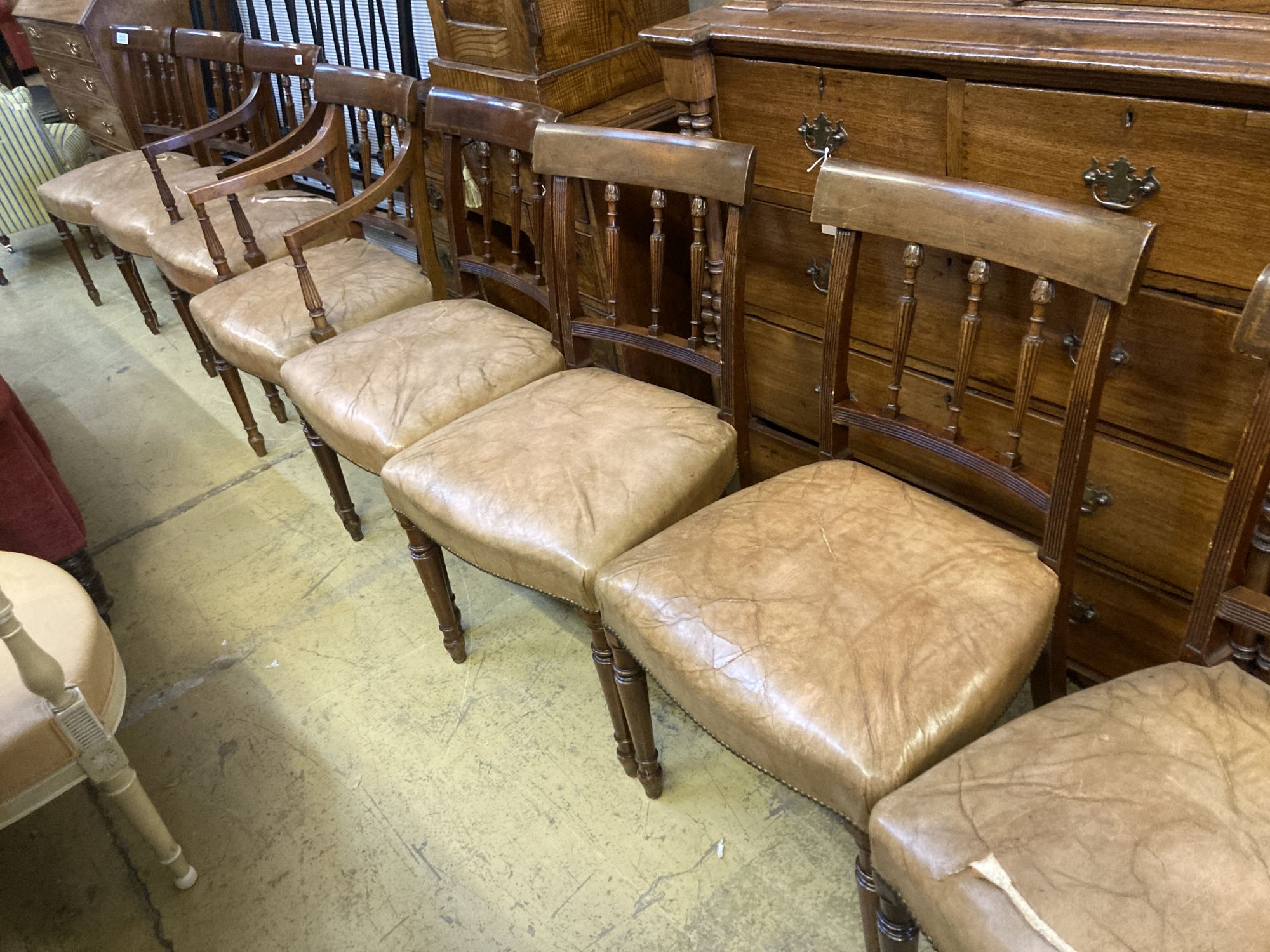 A set of eight George III style Sheraton design mahogany dining chairs, with leather stuff-over seats